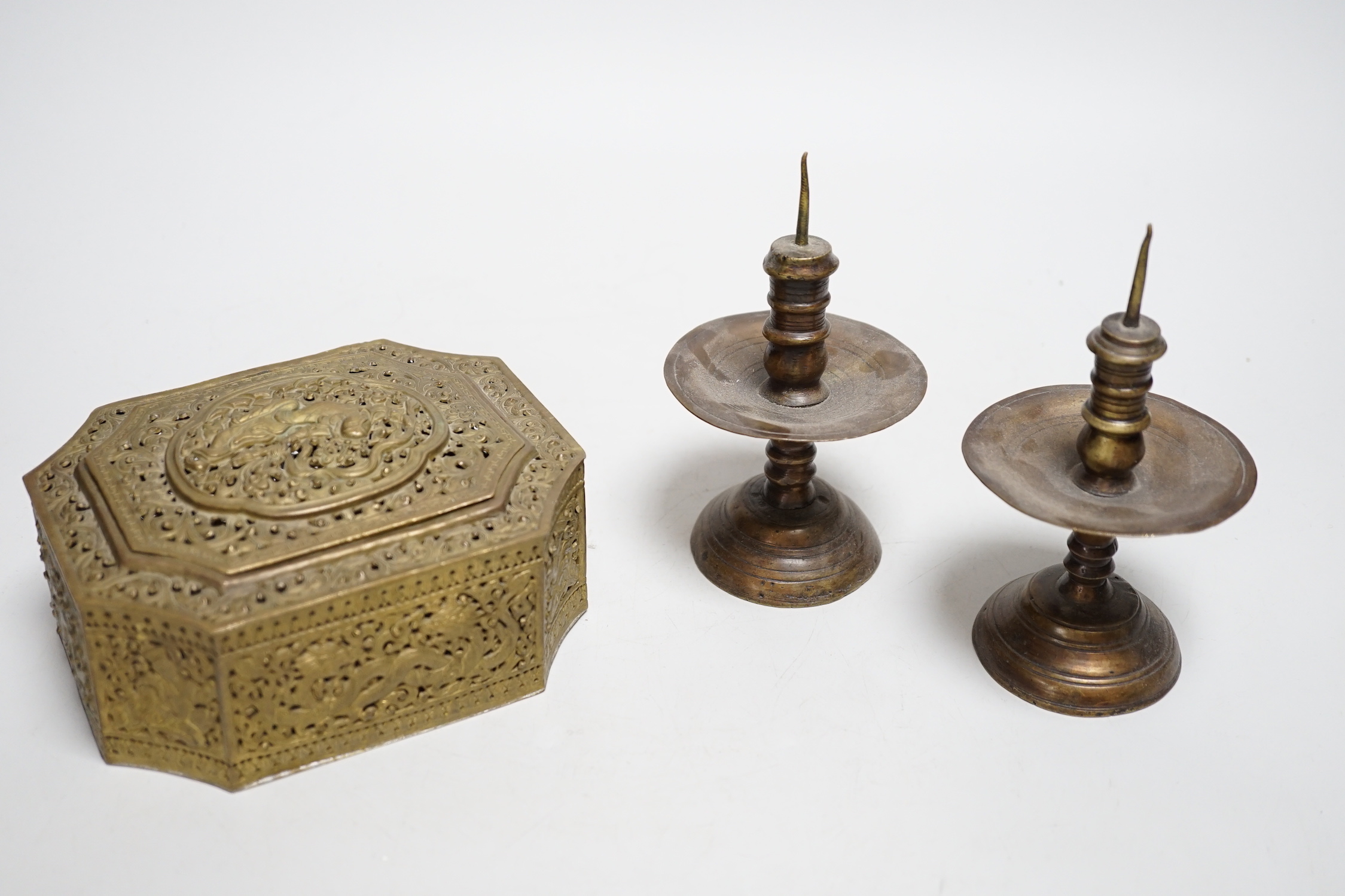 A pair of Middle Eastern bronze pricket candlesticks and an Indian pierced brass casket, candlesticks 14cm high